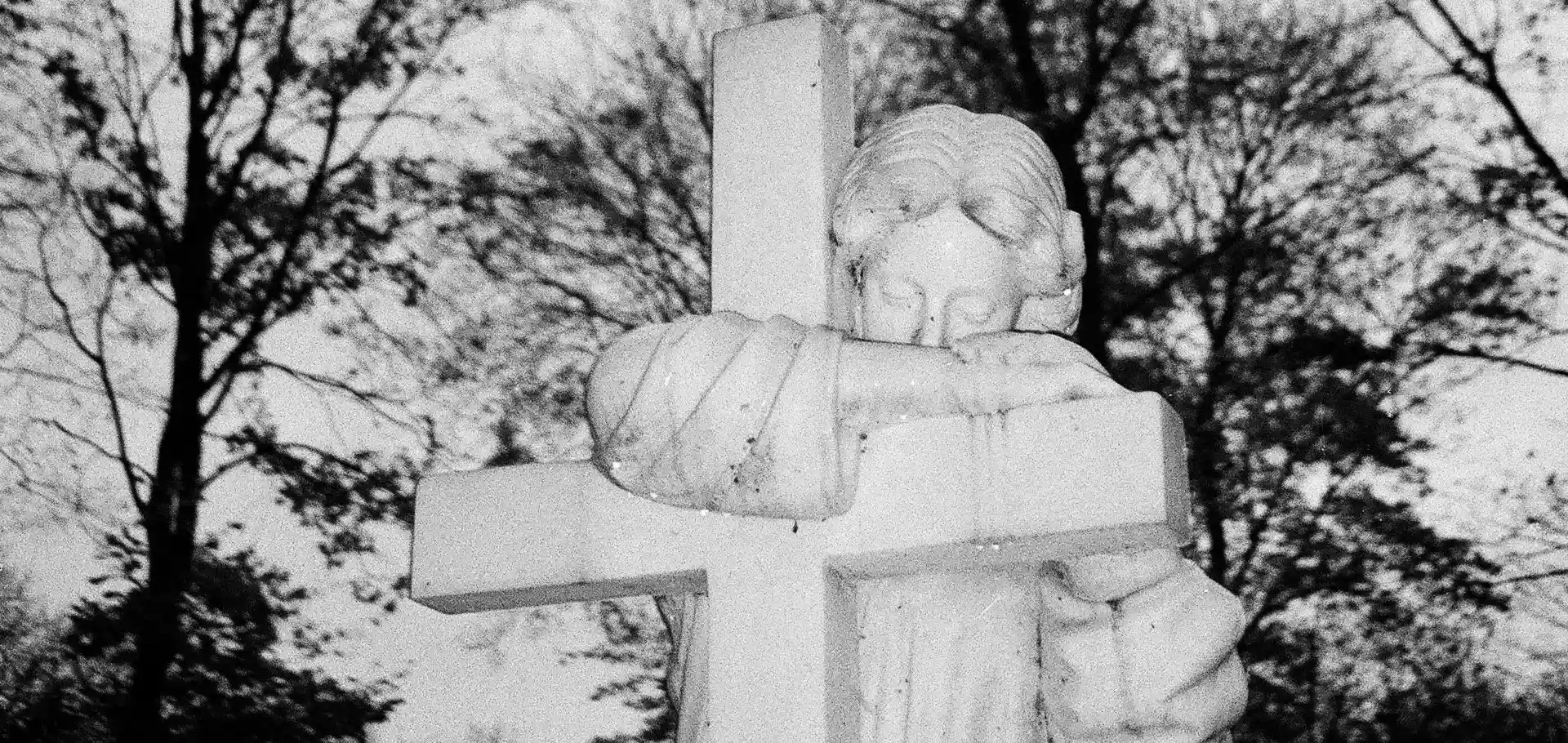 biały posąg i krzyż